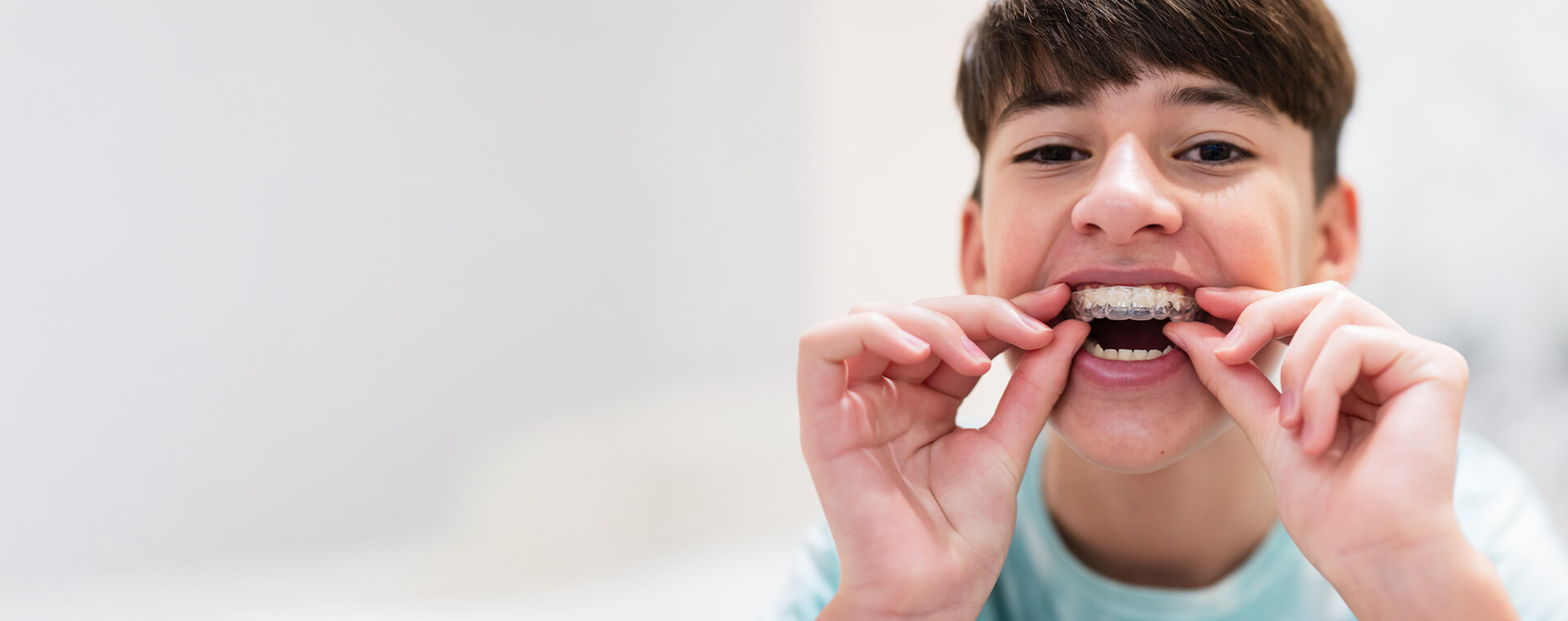 boy inserting clear aligner