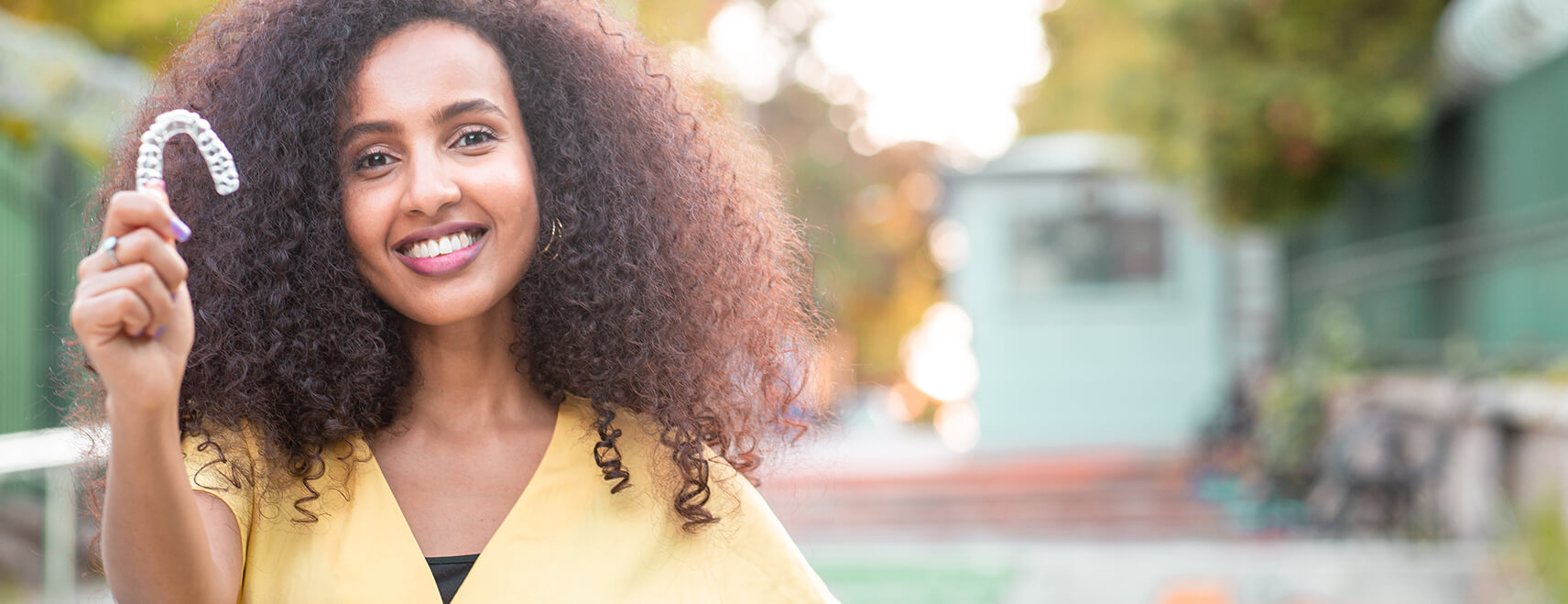 woman holding clear aligner